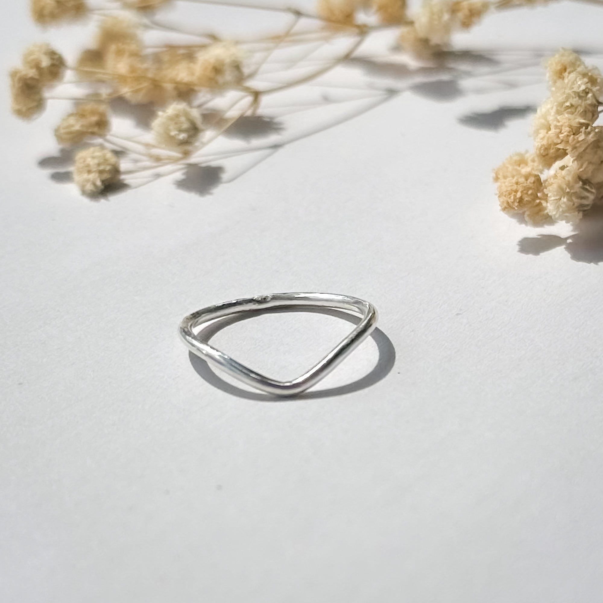 Schmaler 935 Silberring mit V-Form – Schmuckfotografie mit Trockenblumen