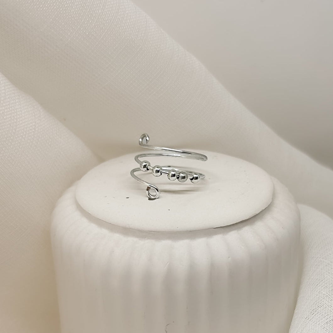 Handgefertigter, minimalistischer Silberring für Damen, edles Schmuckfoto auf hellem Podest, moderner Clean-Girl-Look.