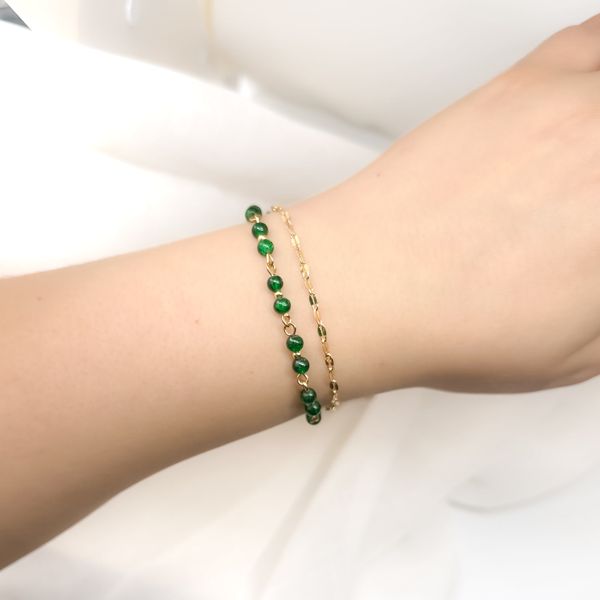 Grünes Perlenarmband mit goldenen Details