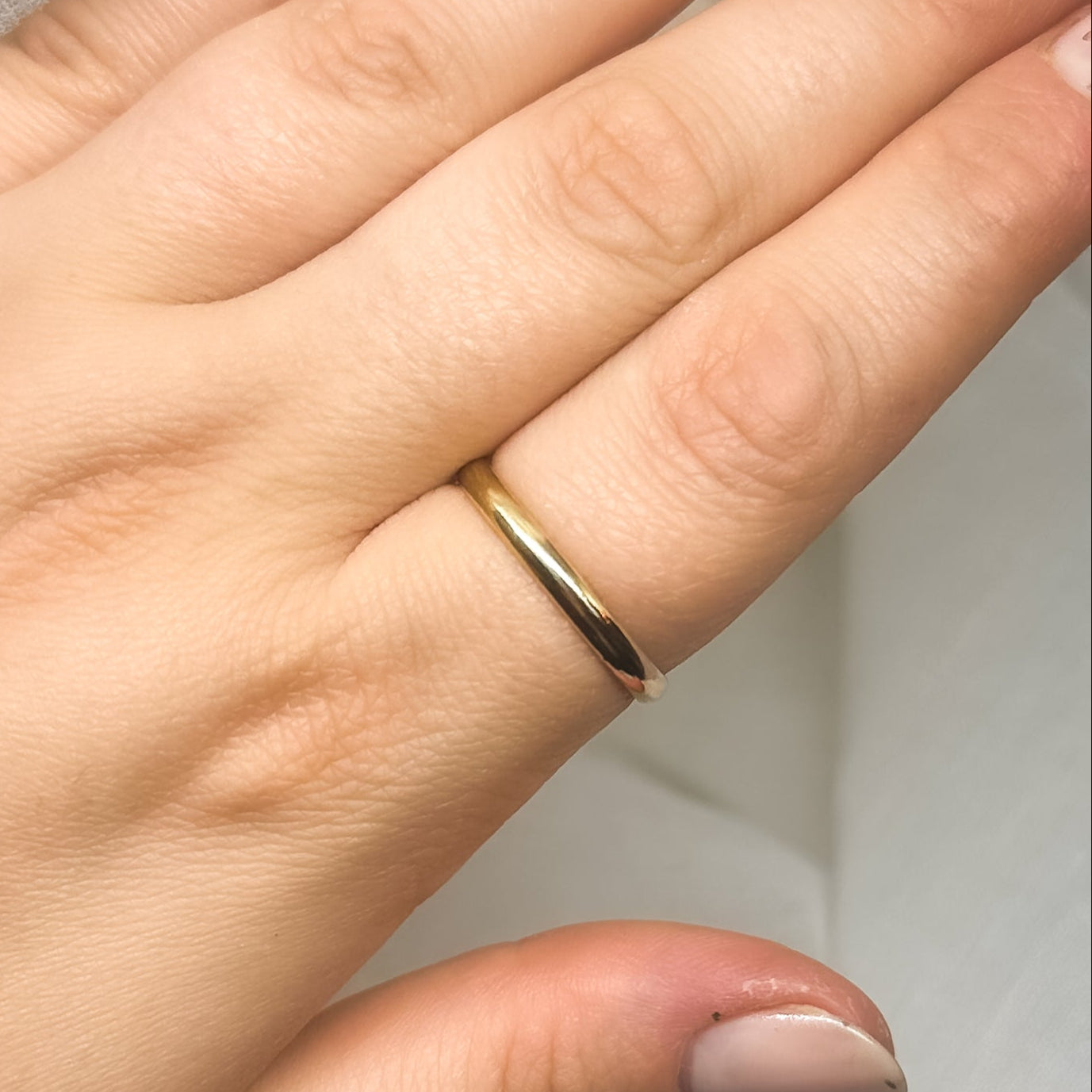 Schlichter goldfarbener Ring an Hand – minimalistische Schmuckfotografie