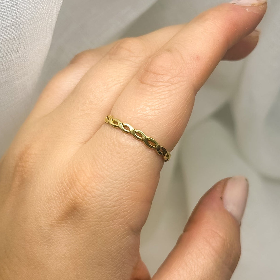 Minimalistischer Messingring mit gedrehter Kettenoptik am Finger – zarter Schmuck für Damen