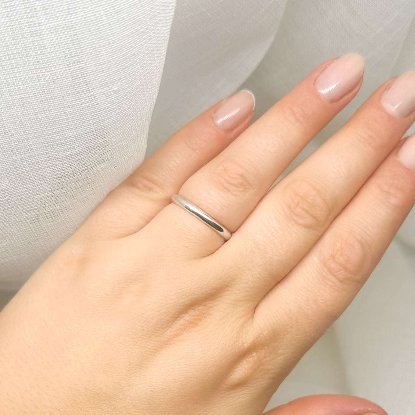 Minimalistischer Silberring an Hand mit Nude-Maniküre – zeitloser Schmuck