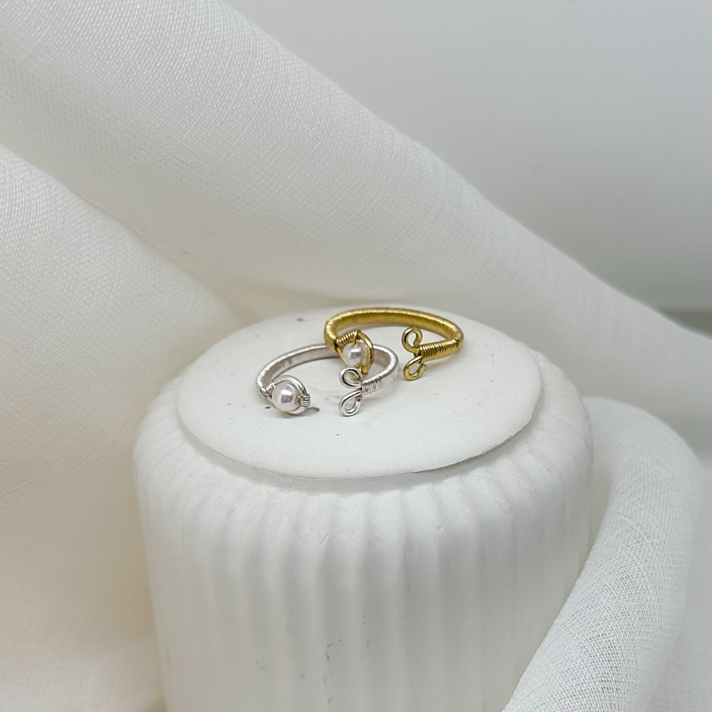 Offene Ringe in Silber und Gold mit Perle– modernes Schmuck-Set auf Podest