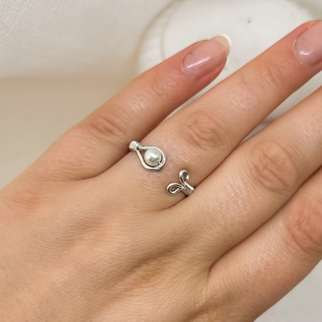 Eleganter offener Silberring mit Perle, minimalistisch am Finger getragen