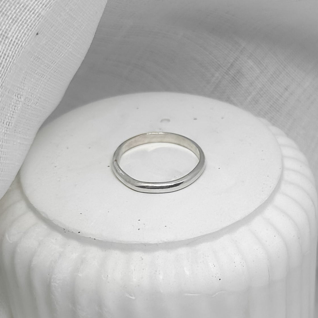 Silberring auf weißem Podest – minimalistisches Produktfoto